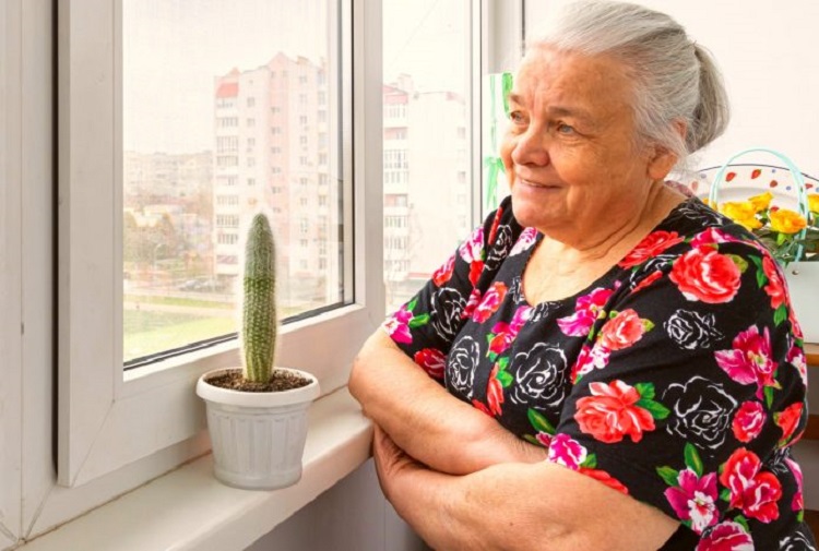 elderly-woman-stands-window-looks-into-distance-1-1-696x469-1.jpg